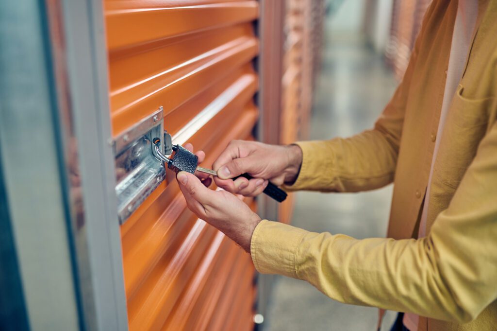 Worker padlocking the door of the storage unit